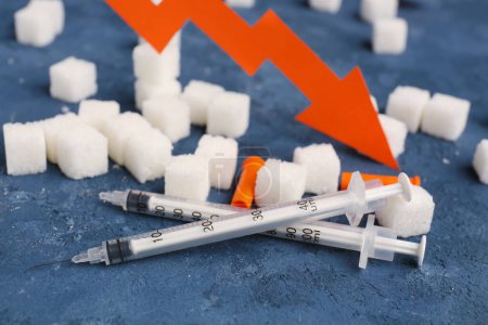 Téléchargez les photos : Cubes de sucre avec seringues pour injection d'insuline sur fond sombre, gros plan - en image libre de droit