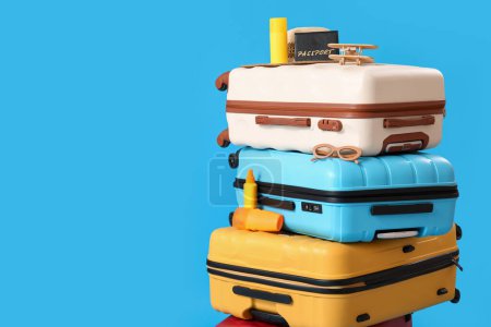 Suitcases with beach accessories on blue background