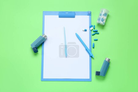 Téléchargez les photos : Composition avec inhalateurs d'asthme, presse-papiers et boîte de pilules sur fond vert - en image libre de droit