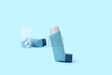 Téléchargez les photos : Inhalateurs d'asthme et boîte de pilules sur fond bleu - en image libre de droit