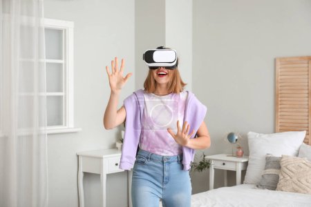 Photo for Pretty young woman in VR glasses in bedroom - Royalty Free Image