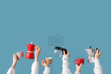 Photo for Female hands holding different coffee makers and cups on blue background - Royalty Free Image