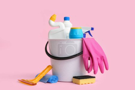 Photo for Bucket with different cleaning supplies on pink background - Royalty Free Image