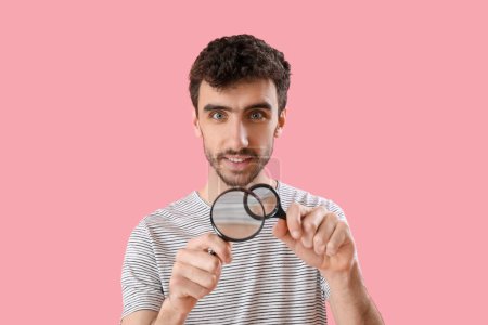 Photo for Young man with magnifiers on pink background - Royalty Free Image