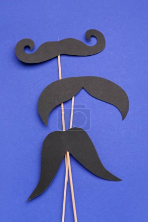Photo for Wooden sticks with different paper mustaches on blue background - Royalty Free Image