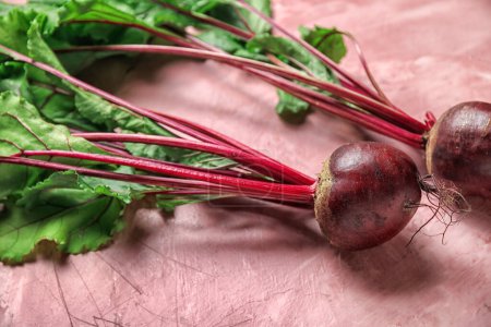 Fresh beets with green leaves on pink background-stock-photo