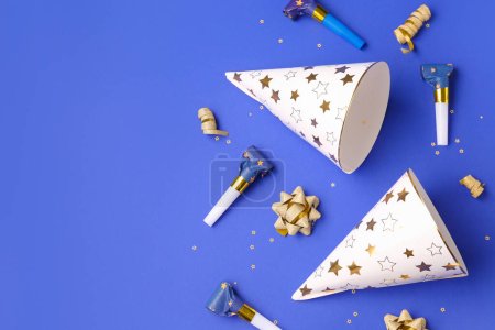 Party hats and whistles on dark blue background
