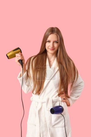 Photo for Beautiful young woman with hair dryers on pink background - Royalty Free Image