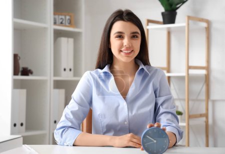 Photo for Businesswoman with alarm clock in office. Time management concept - Royalty Free Image