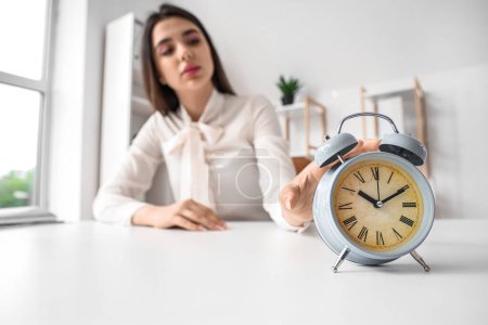 Photo for Businesswoman touching alarm clock in office. Time management concept - Royalty Free Image