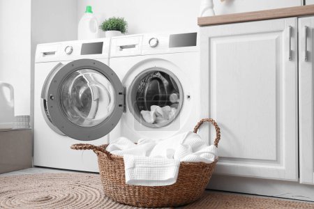 Téléchargez les photos : Lave-linge moderne avec des vêtements sales dans la buanderie - en image libre de droit