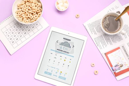 Foto de Tablet ordenador con pronóstico del tiempo, desayuno, calendario y periódico sobre fondo lila - Imagen libre de derechos