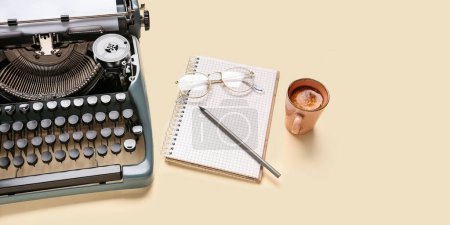 Foto de Máquina de escribir vintage con anteojos, cuaderno, lápiz y taza de café sobre fondo beige - Imagen libre de derechos
