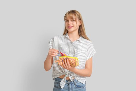 Photo for Female student with pencil case on light background - Royalty Free Image