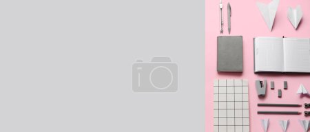 Téléchargez les photos : Avions en papier avec fournitures scolaires sur fond rose et gris avec espace pour le texte - en image libre de droit