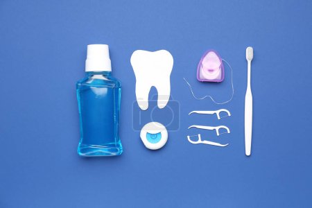 Foto de Set para higiene bucal y modelo de dientes sobre fondo azul - Imagen libre de derechos