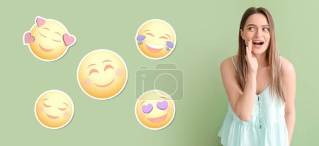 Téléchargez les photos : Jeune femme bavarde et différentes émoticônes souriantes sur fond vert - en image libre de droit