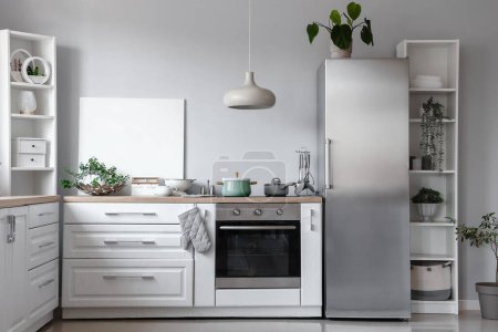 Foto de Interior de la cocina ligera con nevera elegante, mostradores y estanterías - Imagen libre de derechos