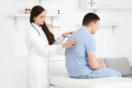 Photo for Female doctor checking posture of young man in clinic - Royalty Free Image