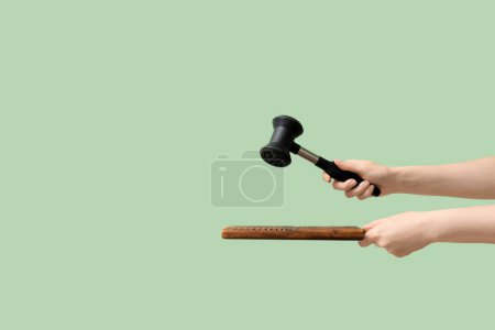 Photo for Woman with meat hammer and board on green background - Royalty Free Image