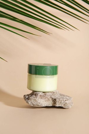 Photo for Jar of cosmetic product, stone and palm leaf on color background - Royalty Free Image
