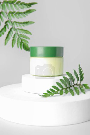 Photo for Composition with jar of cosmetic product, plaster podiums and fern leaves on light background - Royalty Free Image