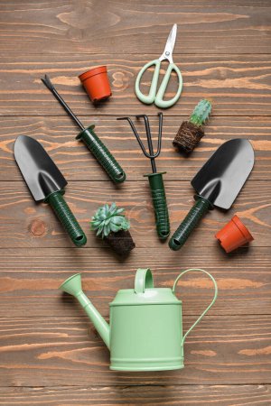 Photo for Composition with gardening tools and plants on brown wooden background - Royalty Free Image