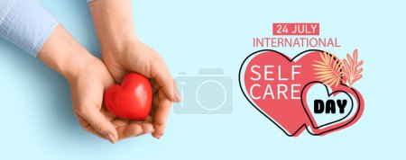 Téléchargez les photos : Bannière pour la Journée internationale de l'auto-soin avec les mains tenant le cœur rouge - en image libre de droit