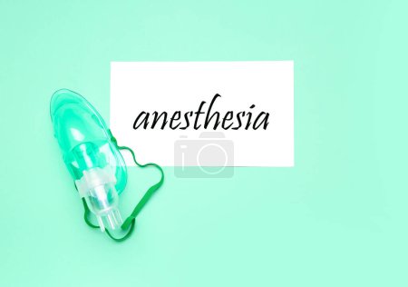 Foto de Papel con palabra ANESTESIA y máscara de oxígeno sobre fondo verde - Imagen libre de derechos