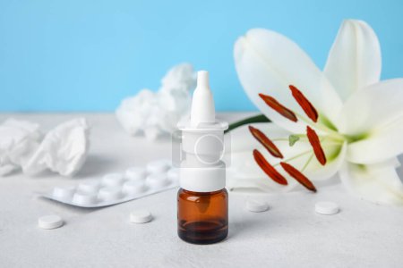 Photo for Nasal drops with pills, flower and tissues on table near blue wall, closeup. Seasonal allergy concept - Royalty Free Image