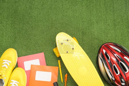 Foto de Casco de bicicleta con zapatillas, monopatín y diferentes artículos de papelería en el fondo de color - Imagen libre de derechos
