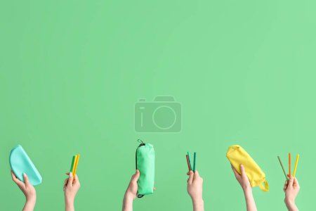 Téléchargez les photos : Hands with school accessories on green background - en image libre de droit