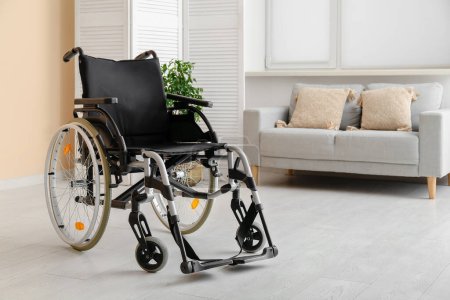 Foto de Moderna silla de ruedas vacía con sofá en el salón - Imagen libre de derechos