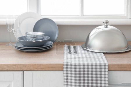 Téléchargez les photos : Comptoir de cuisine avec vaisselle propre et cloche près de la fenêtre - en image libre de droit
