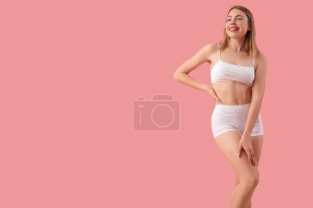 Young woman with cellulite problem on pink background