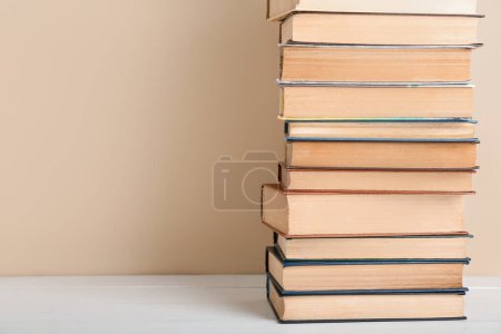 Stack of books on table against beige background