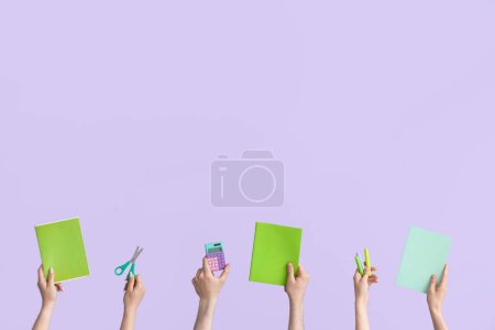 Téléchargez les photos : Hands with school supplies on lilac background - en image libre de droit
