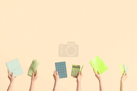 Téléchargez les photos : Hands with school supplies on beige background - en image libre de droit