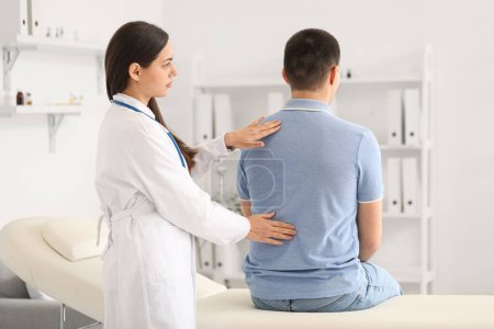 Femme médecin vérifier la posture du jeune homme à la clinique
