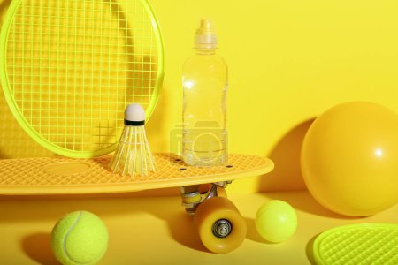 Photo for Set of sports equipment with bottle of water on yellow background - Royalty Free Image