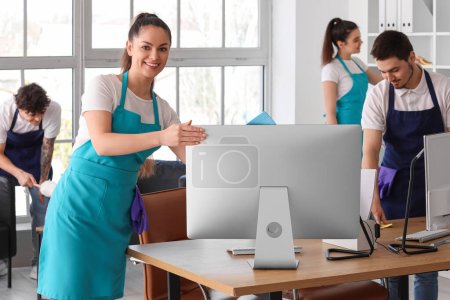 Photo for Young janitors cleaning workplace in office - Royalty Free Image
