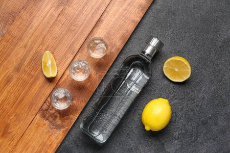 Botella y vasos de vodka con limón en la mesa