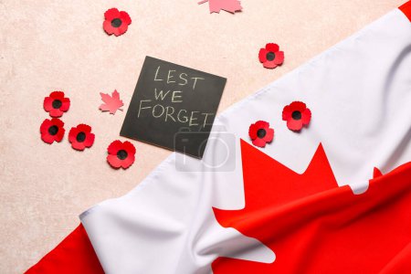 Foto de Flores de amapola con bandera de Canadá y tarjeta sobre fondo rosa grunge. Día del Recuerdo - Imagen libre de derechos