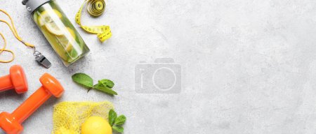 Téléchargez les photos : Bouteille de limonade sportive avec concombre, sifflet et haltères sur fond grunge avec espace pour le texte - en image libre de droit