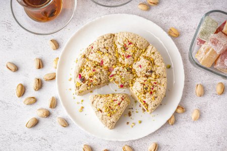 Plate of tasty Tahini halva with pistachios on light background