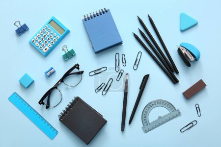 Photo for Different school stationery, notebooks and glasses on blue background - Royalty Free Image