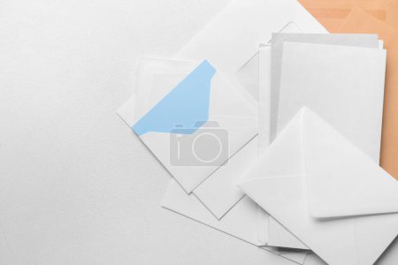 Heap of envelopes and card on light background