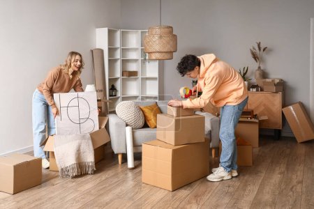 Young couple packing things in room on moving day