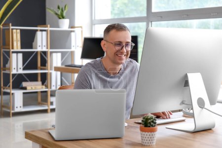 Photo for Mature male programmer working in light office - Royalty Free Image