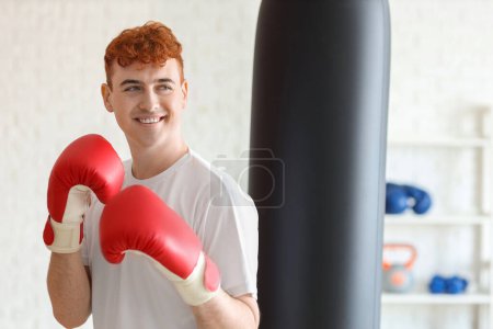 Téléchargez les photos : Jeune boxeur rousse s'entraînant au gymnase - en image libre de droit